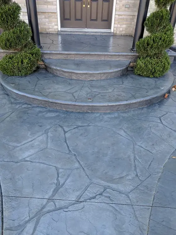 Grey stamped concrete walkway and rounded entrance steps