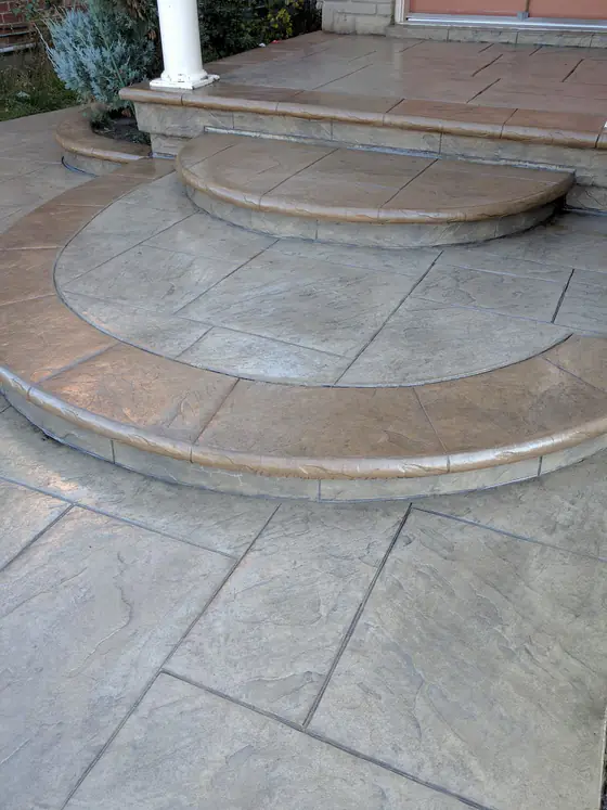 Curved stamped concrete entrance steps with contrasting borders, freshly sealed