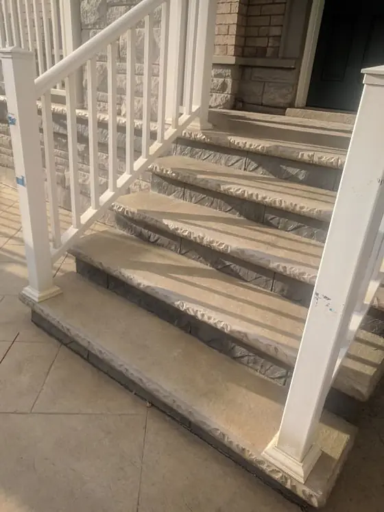 Decorative concrete staircase alongside a cream railing