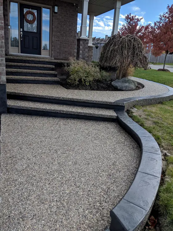Exposed aggregate stairs and winding walkway with dark decorative edging